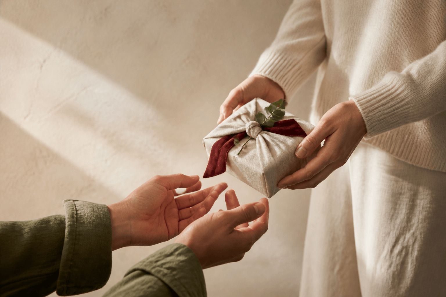 One person handing a carefully wrapped gift to another